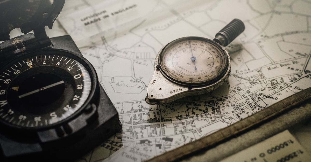 An old compass resting on a worn map, representing meaning as the metric a dashboard cannot show