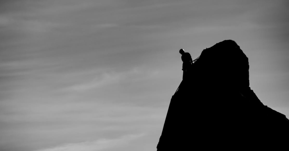 A climber silhouetted on a dark summit, the figure who governs themselves rather than being governed