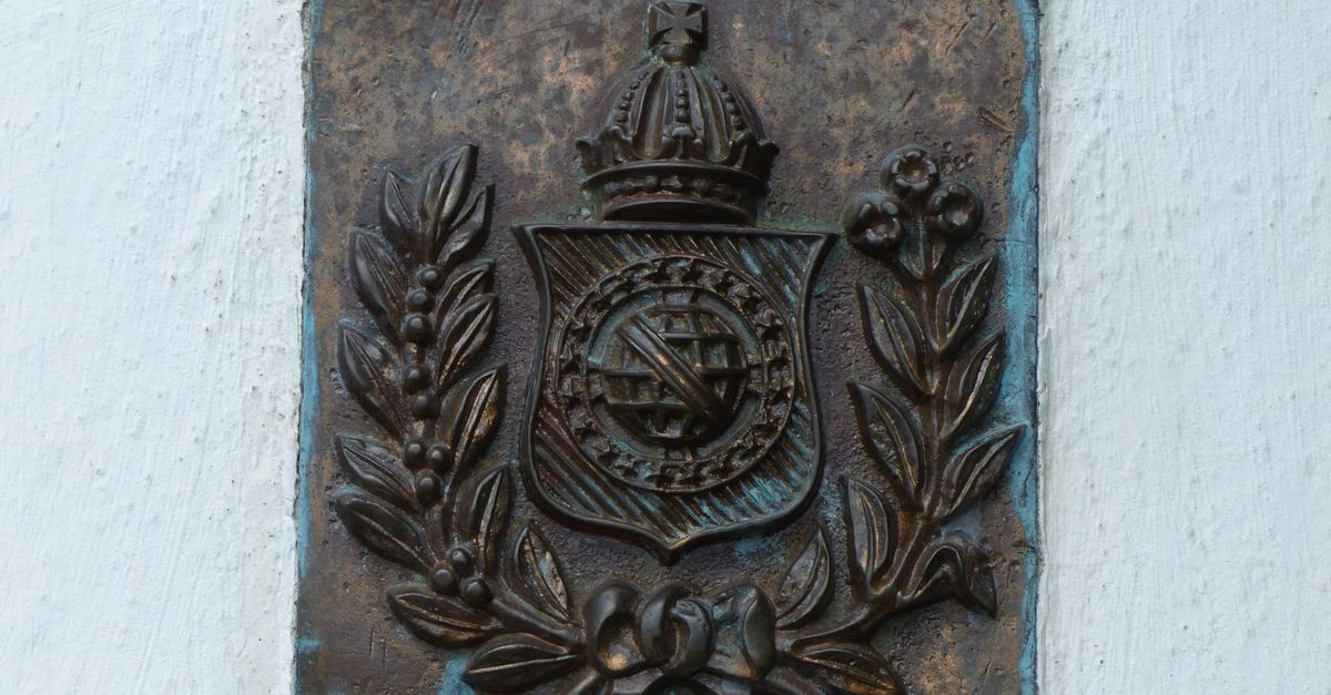 An embossed metal emblem catching gold light against deep shadow