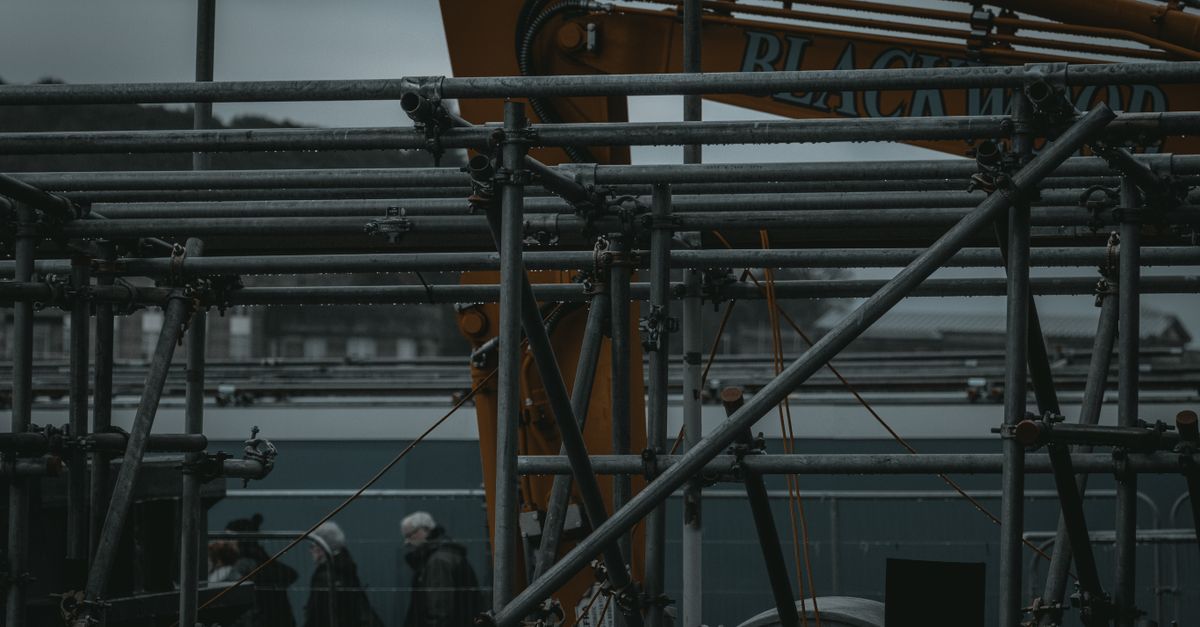 Scaffolding rising against a dark night sky, freedom under construction piece by piece