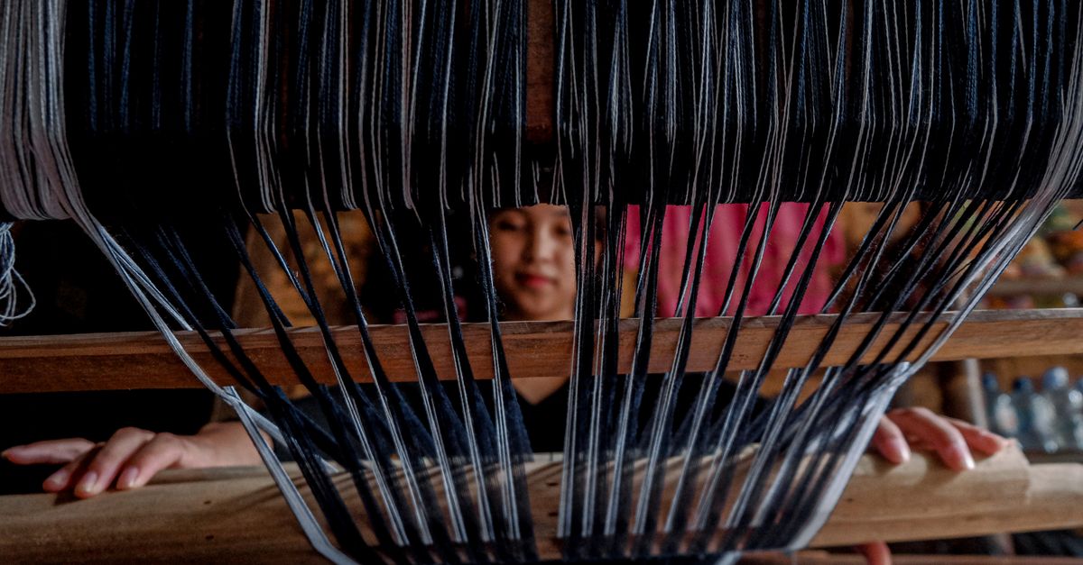 Close weave of ethically made dark textile lit by a single low gold light