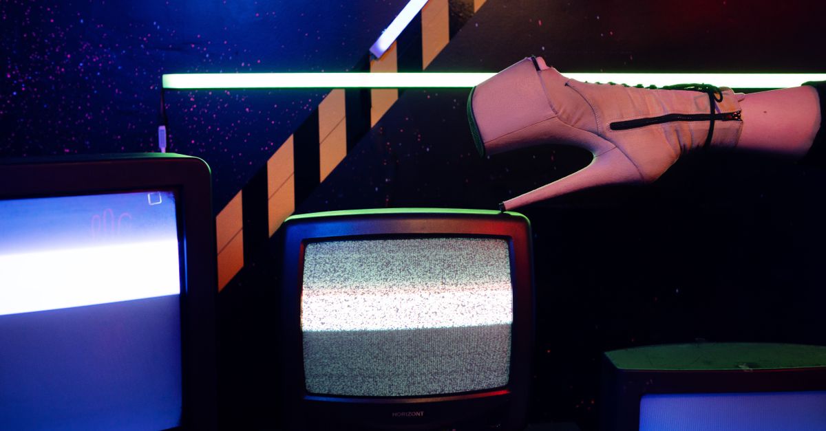 The cold glow of a television in a dark room, static washing over an empty space