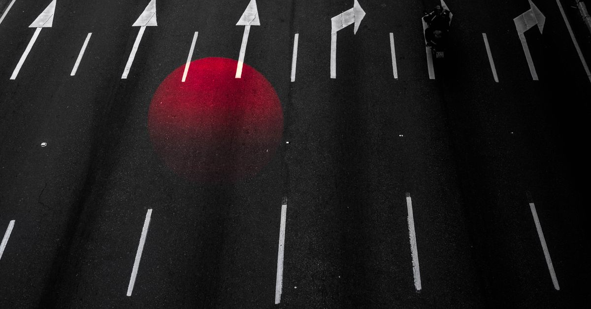 A dark field cut by a single red signal pulse, the manufactured spike of outrage