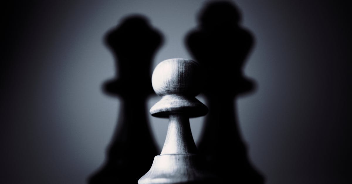 Two chess pieces facing off in low light while the board's edges vanish into dark