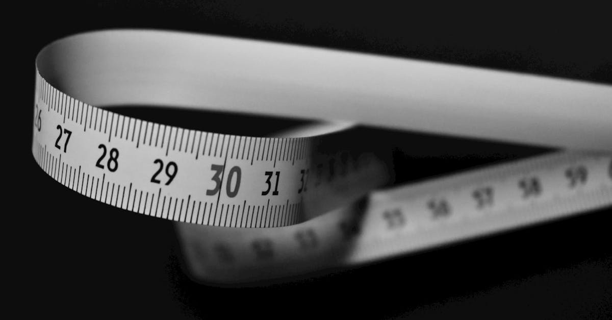 A tailor's measuring tape draped over dark cloth under low gold light