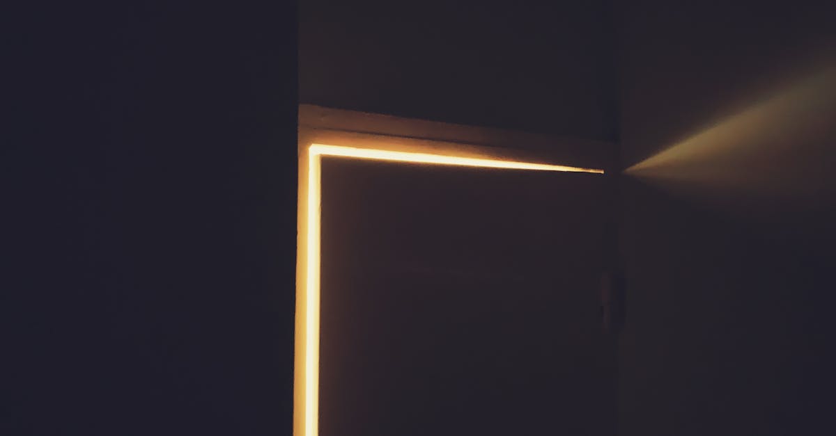 An open doorway in darkness with warm light spilling through from the other side